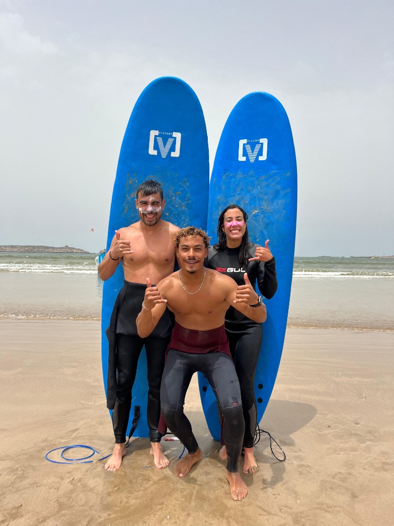 Surf lesson on the beach in Essaouira – students practising pop-up on soft-top boards